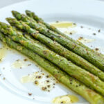 Bunch of cooked asparagus on the white plate